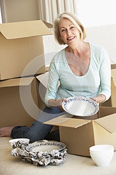 Senior Woman Moving Home And Packing Boxes