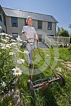 Senior woman mowing lawn