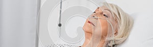 Senior woman with nasal cannula lying