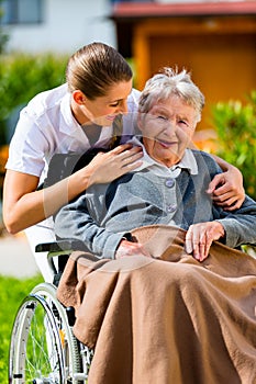 Senior woman in nursing home with nurse in garden