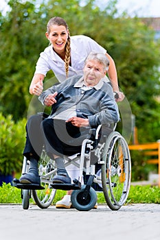 Senior woman in nursing home with nurse in garden