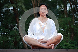 Senior woman open eyes meditation on park