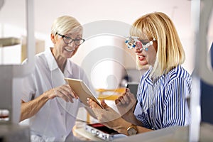 Senior woman optometrist examining patient in modern ophthalmology clinic