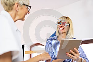 Senior woman optometrist examining patient in modern ophthalmology clinic