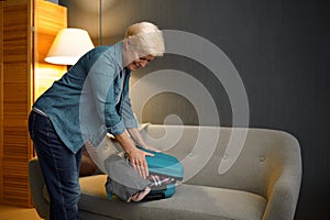 Senior woman packing luggage for new journey