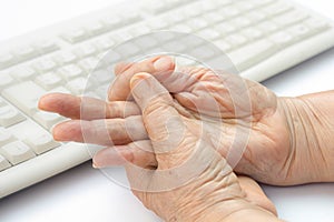 Senior woman painful finger to use keyboard and mouse