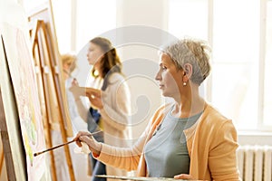 Senior woman painting at art school studio