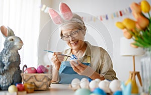 Senior woman painting eggs