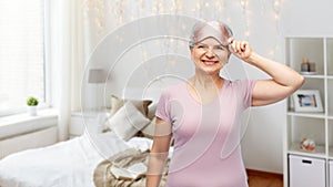 senior woman in pajamas and eye sleeping mask