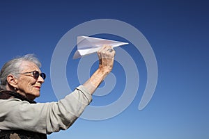 Senior woman with paper plane