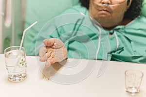 Senior woman patient taking medication in bed in hospital.