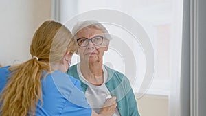Senior woman patient undergoes examining with stethoscope and doctor listens to heartbeat