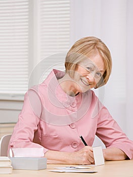 Senior woman paying bills at desk