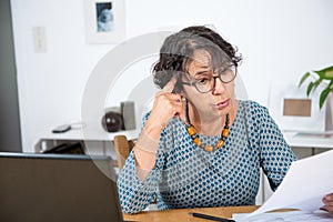 Senior woman paying bills with laptop at home