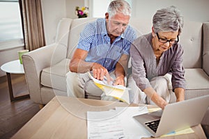 Senior woman paying bills online on laptop