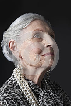 Senior Woman With Pearl Earrings Looking Up