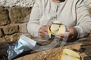 A senior woman, peel half an apple to eat, Spain