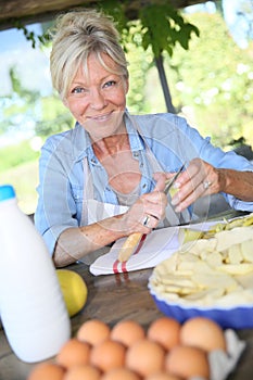 Senior woman peeling apples