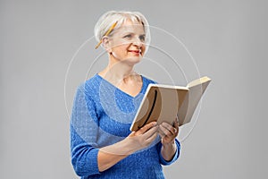 Senior woman with pencil and diary or notebook