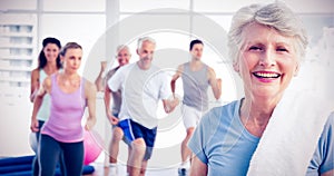 Senior woman with people exercising in fitness studio