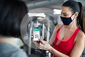 Senior woman with personal trainer doing exercise in gym, coronavirus concept.