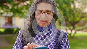 Senior woman, phone or internet game on nature park background, public Brazil garden or nursing home backyard