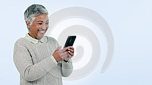 Senior woman, phone and laugh in studio by space for mockup, chat or funny meme by blue background. Mature lady