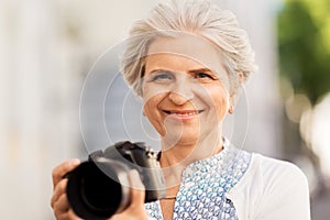 Senior woman photographing by digital camera