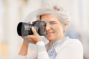 Senior woman photographing by digital camera