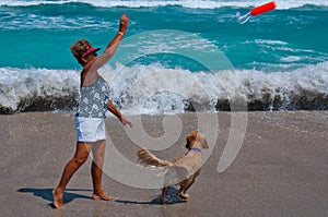 Senior Woman Playing with Dog on a Florida Beach.