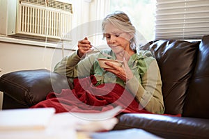 Senior Woman With Poor Diet Keeping Warm Under Blanket photo