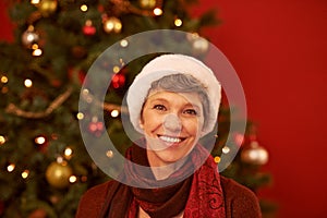 Senior, woman and portrait on Christmas with smile for celebration, holiday and festive season with tree for decoration