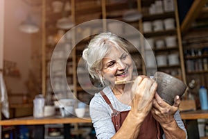 Senior woman pottery artist makes ceramics from clay