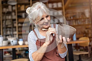 Senior woman pottery artist makes ceramics from clay