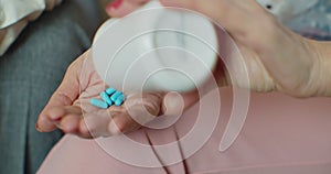 Senior woman pouring painkiller pills on a hand from a bottle of medicine. Old elderly grandmother health care, pharmacy