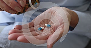 Senior woman pouring pills on hand taking medicine, close up