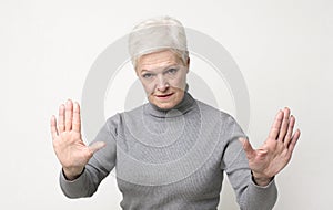 Senior woman practicing hypnosis, looking mysteriously at camera