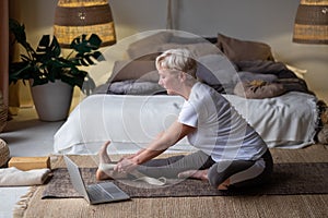 Senior woman practicing yoga concept, sitting in Janu Sirsasana exercise, Head to Knee Forward Bend pose