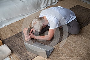 Senior woman practicing yoga concept, sitting in Janu Sirsasana exercise, Head to Knee Forward Bend pose