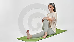 Senior woman practicing yoga on fitness mat