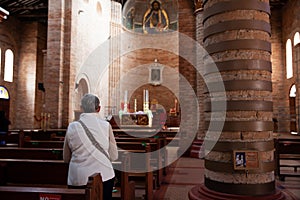 Senior woman praying at the historical Cathedral of Our Lady of Poverty of Pereira, built in 1890