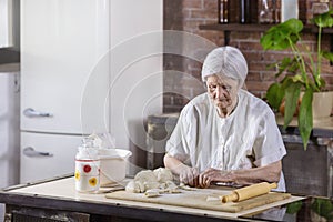 Senior woman preparing pastries in the kitchen at home