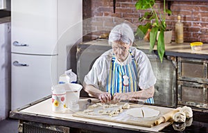 Senior woman preparing pastries in kitchen at home