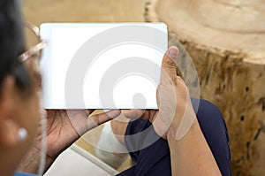 Senior woman professionally attired, holding a modern tablet with a clean, blank screen towards the camera with a serene photo