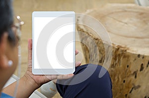Senior woman professionally attired, holding a modern tablet with a clean, blank screen towards the camera with a serene photo