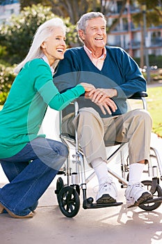 Senior Woman Pushing Husband In Wheelchair