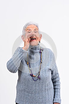 Senior woman putting a hand in labo and is screaming on white background photo