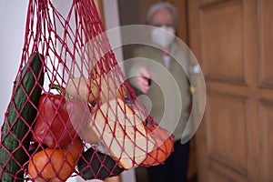 Senior woman reaching for groceries