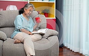 Senior woman reading book, enjoy and relax, stay alone at home. Enjoying Retirement And Time On Isolation, grandparents care,