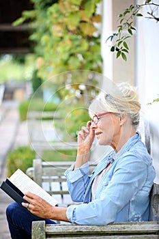 Senior woman reading book in the garden